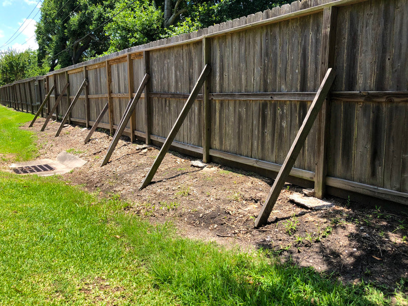 This is a wooden fence we recently installed, and we had to put 2x4 posts on an angle up against the backside of the fence for extra support.